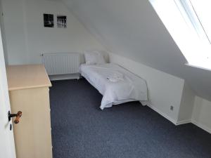 阿森斯Skrædderens hus的一间卧室配有一张带白色毯子的床