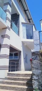 乌提Sandy Luxury 4 Bhk Villa的前面有楼梯的白色建筑