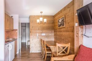 阿沃里亚兹Résidence Quartier Falaise - maeva Home - Studio 4 Personnes - Confort 69的一间厨房和带木墙的用餐室