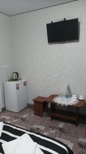 赫梅利尼茨基Готель Ассоль的一间房间,墙上有桌子和电视