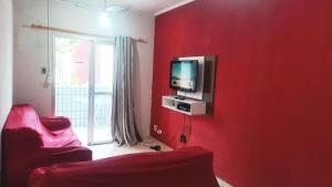蒙加瓜Apartamento Praia Mongagua的红色的房间,红色的墙上配有电视