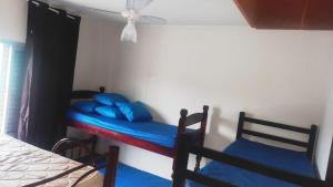 蒙加瓜Apartamento Praia Mongagua的一间卧室配有两张双层床和蓝色枕头