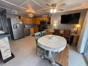 格尔夫海岸Paradise PRN的厨房配有桌椅和冰箱。