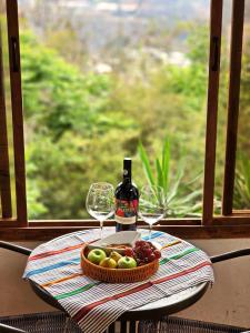 危地马拉CABAÑAS EN ZONA 16的一张桌子,上面放着一盘水果和一瓶葡萄酒