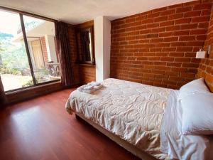 巴尼奥斯Casa de Campo El Descanso的一间卧室设有一张床和砖墙