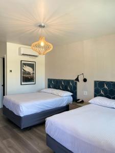 安纳海姆阿纳海姆梅因盖特汽车旅馆的酒店客房设有两张床和吊灯。