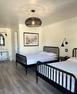 安纳海姆阿纳海姆梅因盖特汽车旅馆的一间卧室配有两张床和吊灯。