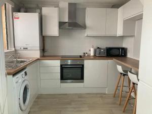 南安普敦Southampton Lodge的厨房配有白色橱柜和一台洗衣机