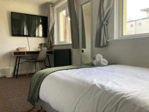 南安普敦Southampton Lodge的一间卧室配有一张床、一张书桌和一台电视