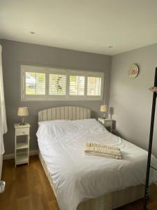 哈佛威斯特Meadow cottage的卧室配有白色床和2扇窗户