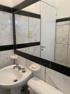 蒂诺加斯塔Urqu-Pacha Alojamiento的白色的浴室设有水槽和镜子