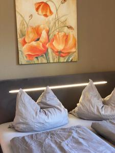 格拉尔-米里茨Zur Fledermaus的一张带两个枕头的床和一幅鲜花画