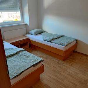 ŠoštanjSOSTANJ VELENJE RAVNE SOBE ROOMS Vrtacnik d o o的一间卧室设有两张床和窗户。
