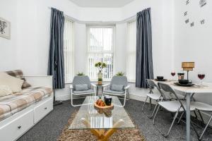 伯肯黑德Cosy Wirral home near Liverpool with Free Parking!的客厅配有沙发和桌椅