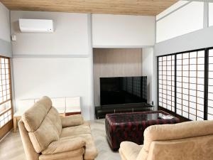 出云市Izumo no Oyado Naka Araki - Vacation STAY 82773v的客厅配有2把椅子和平面电视