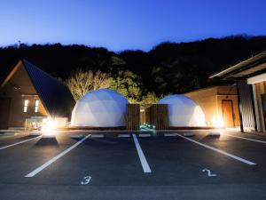 广岛Riverside Glamping Kamiseno - Vacation STAY 92770v的大楼旁停车场的两顶圆顶