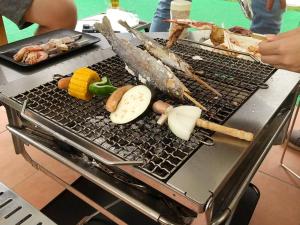 广岛Riverside Glamping Kamiseno - Vacation STAY 92770v的烤架上放不同种类的食物