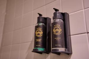 里约热内卢南美克巴卡巴纳酒店的浴室墙上有2瓶黑洗发水