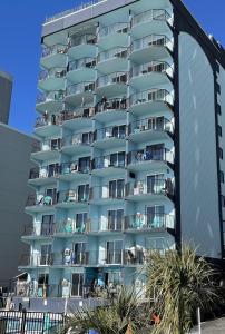 默特尔比奇Blue Palmetto的一座高大的公寓楼,前面有棕榈树
