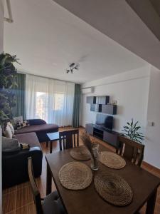 RoşuCosy Spacious Apartment with Parking, Wi-Fi, Smart-TV Netflix的一间带桌椅的客厅和一间客厅。