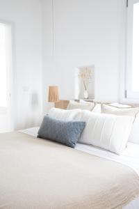安提帕罗斯岛KAMEO, Antiparos的一张带白色床单和蓝色枕头的床