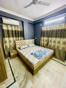海得拉巴Prince Castle-2BHk Luxurious Apartment/Guesthouse的一间带床的卧室,位于带窗帘的房间
