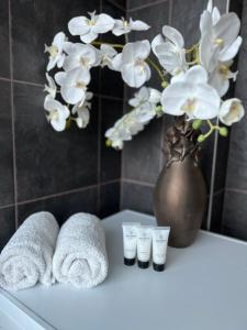 塔林Luxurious, Skyline View Apartment near Centre的浴室提供毛巾和鲜花花瓶