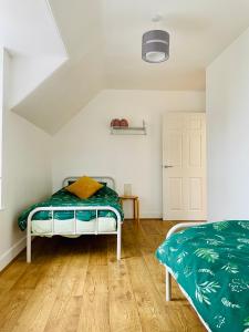 艾茅斯The Crows Nest的一间卧室配有一张带绿色棉被的床