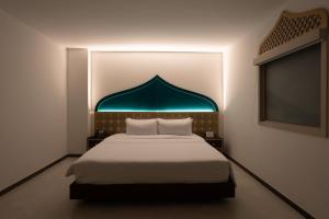 圣安德烈斯Prixma Hotel的一间卧室配有一张蓝色天蓬大床