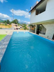 塔拉波托Sonqu Tarapoto的房子前面的蓝色游泳池