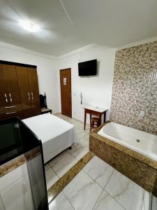 瓦拉达里斯州长市POUSADA BRASÃO的酒店客房配有一张床和浴缸。