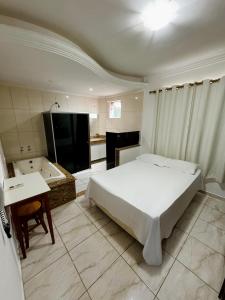 瓦拉达里斯州长市POUSADA BRASÃO的一间卧室配有一张床和一个水槽和一个浴缸