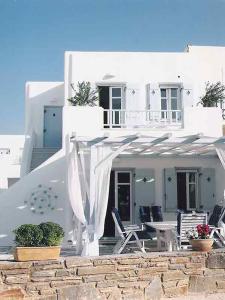 帕罗斯岛Dolce Vita Waterfront Villa, Logaras, Paros的白色的房子前面设有椅子和桌子