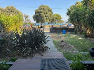 North ShoreGeelong Luxury Beach K Villa的一个带木人行道和一些植物的花园