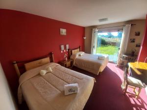 普诺Hotel Pumakala的一间卧室设有两张床和红色的墙壁