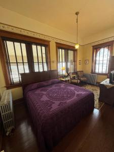 克里普尔克里克Cripple Creek Hospitality House & Travel Park的一间设有窗户的客房内的带紫色床的卧室
