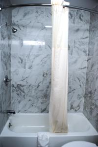 Van BurenVan Buren Inn的浴室配有白色的浴缸和淋浴帘