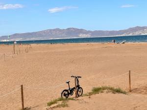 圣马蒂登普里斯Villa Mercè Empúries的停在海边沙滩上的自行车