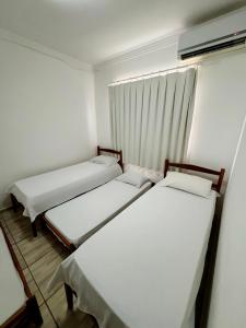 瓦拉达里斯州长市POUSADA BRASÃO的一间小房间设有三张床,设有窗户