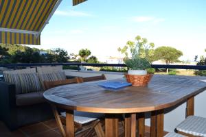 托雷加迪亚罗Beach and Golf House Sotogrande - Torreguadiaro的天井上木桌,种植了盆栽植物