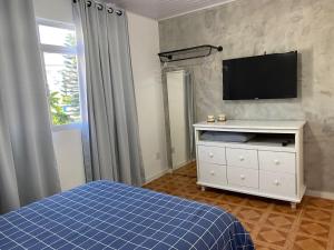 弗洛里亚诺波利斯Residencial Sullivan - Florianópolis - Loft 01的一间卧室配有一张床,墙上配有电视