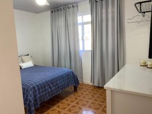 弗洛里亚诺波利斯Residencial Sullivan - Florianópolis - Loft 01的一间卧室设有蓝色的床和窗户。