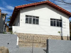 弗洛里亚诺波利斯Residencial Sullivan - Florianópolis - Loft 01的白色的房子,设有两扇窗户和围栏