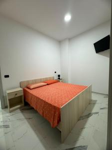 拉卡莱Dimora San Nicola的一间卧室配有一张带橙色棉被的床