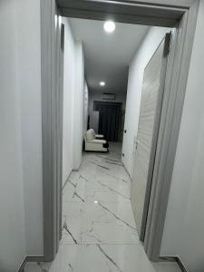 拉卡莱Dimora San Nicola的走廊铺有大理石地板,设有白色墙壁。