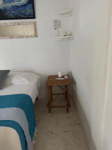 奥尔沃克斯岛Cuarto chingui的一间卧室配有一张床和一个带桌子的床头柜