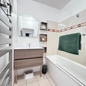 塞里斯Cosy Apartment Carré Elysée Serris的带浴缸、水槽和浴缸的浴室