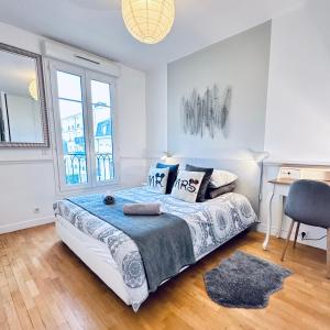 塞里斯Cosy Apartment Carré Elysée Serris的卧室配有一张床、一张书桌和窗户。