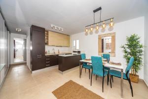 宏达海滩Luxury Apartment Chalana的厨房以及带桌椅的用餐室。