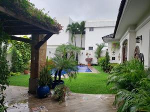 瓜亚基尔Casa en Samborondón的一座带游泳池和植物的庭院